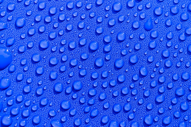 透明的静水滴在浅蓝色的背景。蓝色的水滴。雨滴落在玻璃上。蓝色抽象水滴背景。水面图片下载