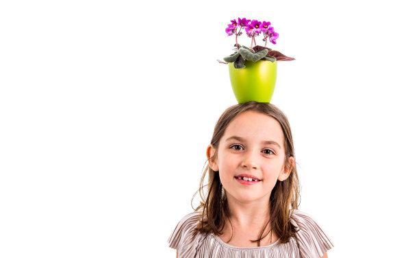 女孩头顶着花盆，开心地笑着。图片下载