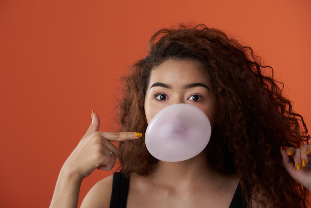 一个拿着泡泡糖的女孩的滑稽肖像图片下载