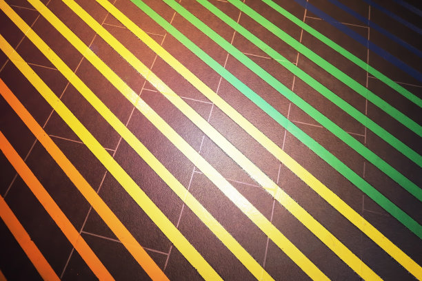 特写黑色瓷砖地板和平行的彩色条纹与闪亮的聚光灯。图片下载