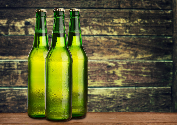 一组冷湿啤酒瓶在垃圾背景图片下载