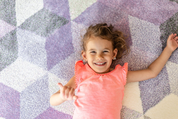 漂亮的小女孩在地毯上玩耍图片下载