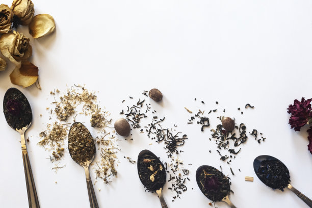 各种干茶在勺子上白。一种干茶。不同的草药健康干茶。茶叶干了就白了图片下载