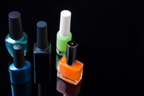 指甲油在一个白色的黑色背景孤立，与空间。在美容院洒指甲油。指甲油颜色可选择用于修指甲或修脚。图片下载