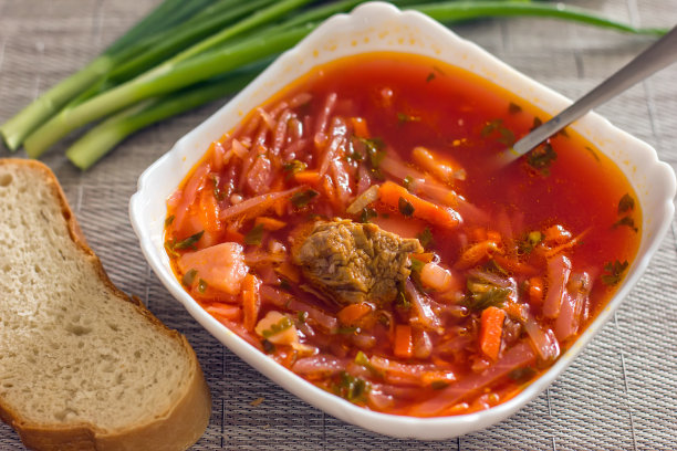 乌克兰甜菜根汤——罗宋汤放在厨房桌子上的白色碗里。美味的甜菜汤。餐桌上新鲜的罗宋汤被产品包围-图片图片下载