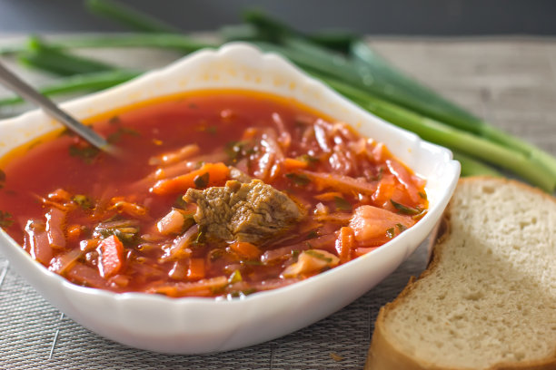 乌克兰甜菜根汤——罗宋汤放在厨房桌子上的白色碗里。美味的甜菜汤。餐桌上新鲜的罗宋汤被产品包围-图片图片下载