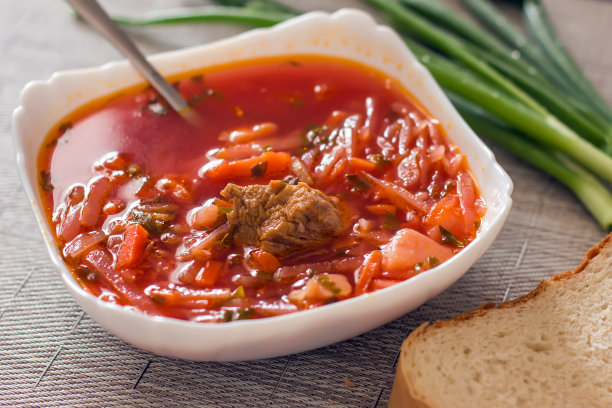 乌克兰甜菜根汤——罗宋汤放在厨房桌子上的白色碗里。美味的甜菜汤。餐桌上新鲜的罗宋汤被产品包围-图片图片下载