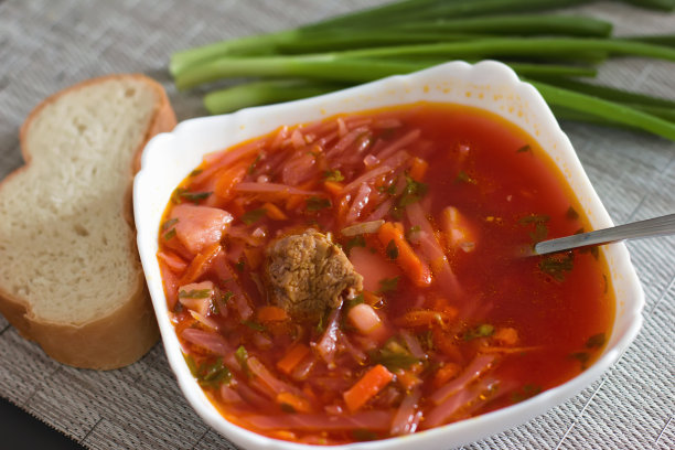 乌克兰甜菜根汤——罗宋汤放在厨房桌子上的白色碗里。美味的甜菜汤。餐桌上新鲜的罗宋汤被产品包围-图片图片下载