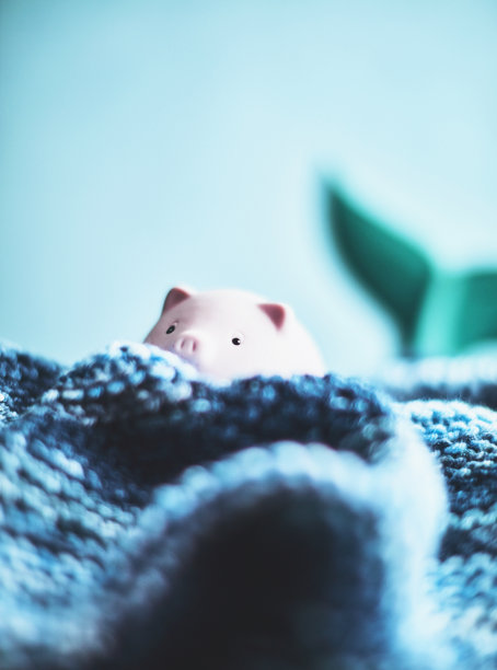 粉红色的小储蓄罐试图在手工制作的波浪中漂浮图片下载