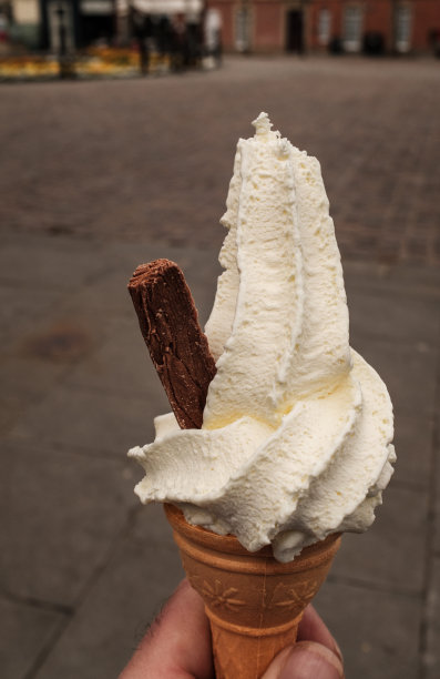 这是一个手握的奶油冰淇淋的肖像照片，侧面有一块巧克力片，孤立在一个普通的背景下图片下载