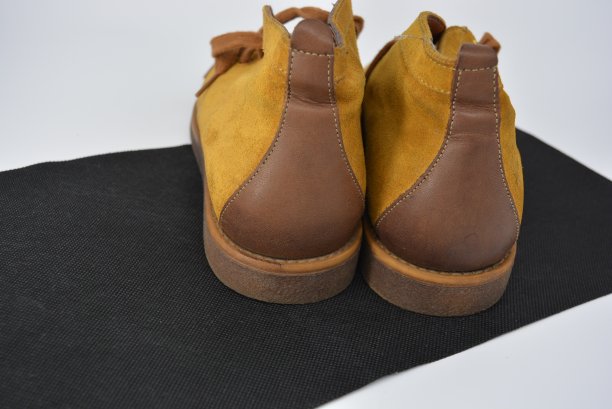 女士的棕色秋季皮靴由天然绒面革和皮革插入，女性的时尚风格和美丽在一个白色和黑色的背景。图片下载