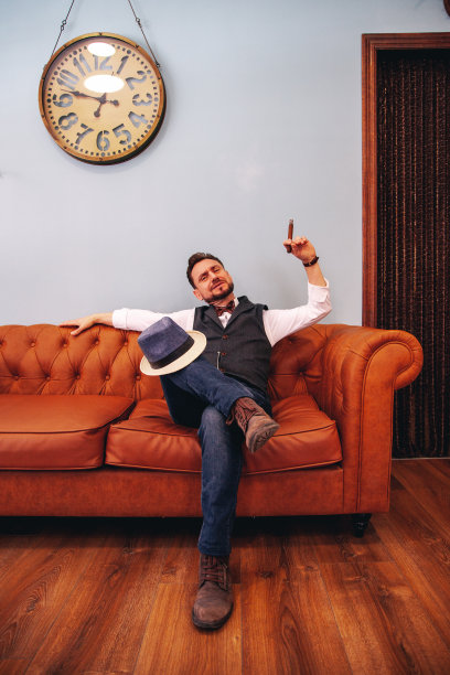 一个男人坐在沙发上抽雪茄图片下载