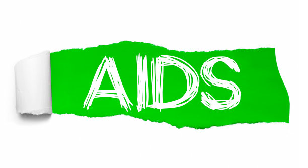 世界艾滋病出现在绿色的破纸后面图片下载