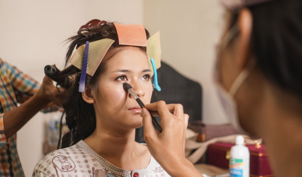 美丽的概念。化妆师为眼睑化妆。涂抹眼影的年轻女子，图片下载