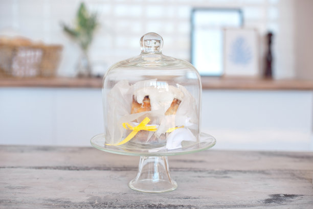 在一间明亮的房间里，蛋糕架的玻璃盖放在一张白色的桌子上图片下载