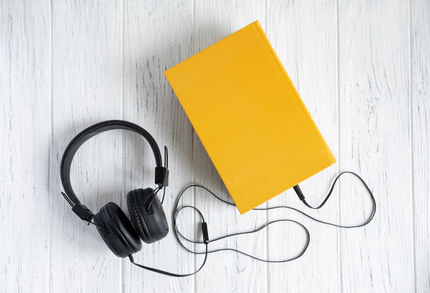 书的照片和耳机连接在上面。音频书。关于远程学习主题的概念性照片。听书是为了学习。图片下载