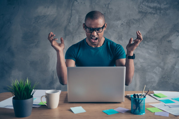 近距离的照片惊人的愤怒他他他的大男子主义英俊的笔记本桌子绿色的植物可靠的人努力不能做使任务任务穿specs蓝色的t恤裤子坐在椅子室内工作站办公室图片下载