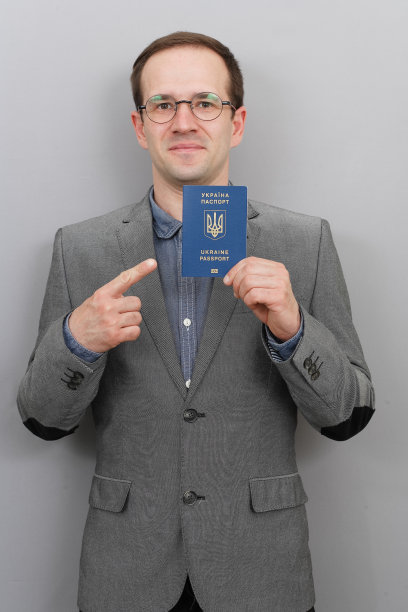一个穿着夹克或燕尾服，手里拿着乌克兰护照的男人。一个戴眼镜的男人，还有一张护照照图片下载
