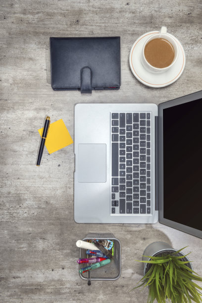 俯视图的商务办公桌与笔记本电脑，便利贴，咖啡，盆栽植物，笔记本和商务配件图片下载