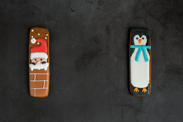 黑色背景上的两个姜饼作为礼物。文本。圣诞节的心情。图片下载