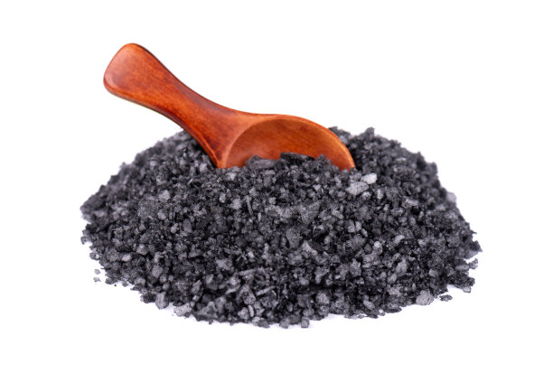 木勺里的黑色海盐，孤立在白色背景上。火山盐晶体。图片下载