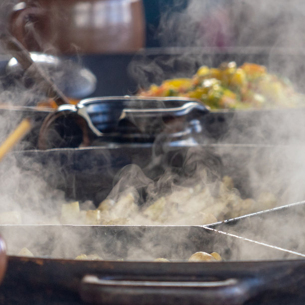 拍摄大蒸锅，蒸汽在前景聚焦，蔬菜锅在背景故意模糊图片下载