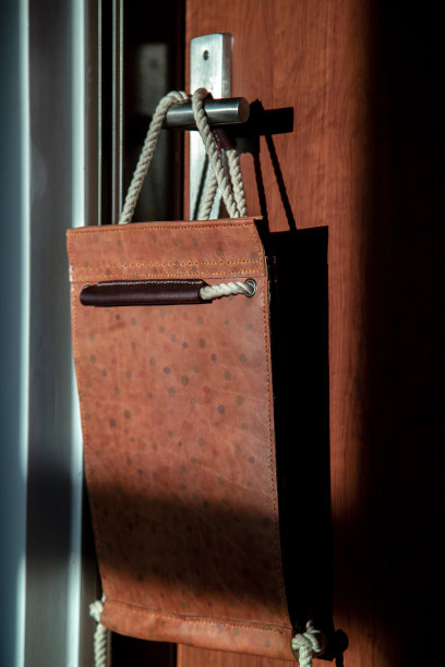 休闲皮包挂在门把手上图片下载