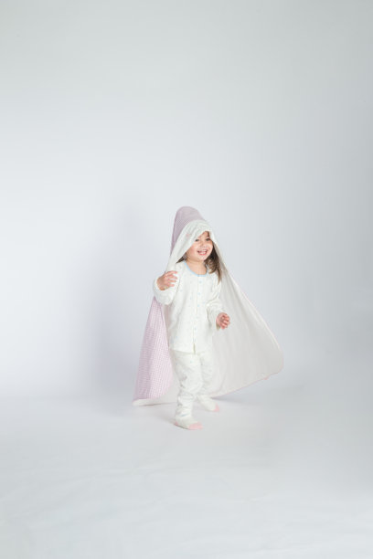 一个小女孩抱着一个婴儿，孩子站在地板上。水平的照片。浅灰色背景图片下载