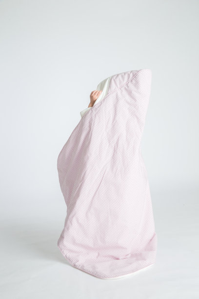 一个小女孩抱着一个婴儿，孩子站在地板上。水平的照片。浅灰色背景图片下载