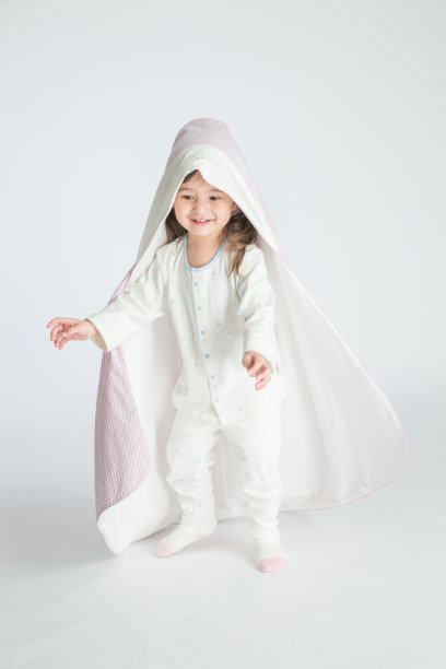 一个小女孩抱着一个婴儿，孩子站在地板上。水平的照片。浅灰色背景图片下载