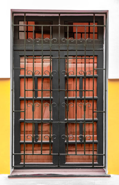 非常漂亮的科林斯式大窗户，有带图案的铁栏杆和木门。典型的殖民地时代罗马建筑。——图片图片下载