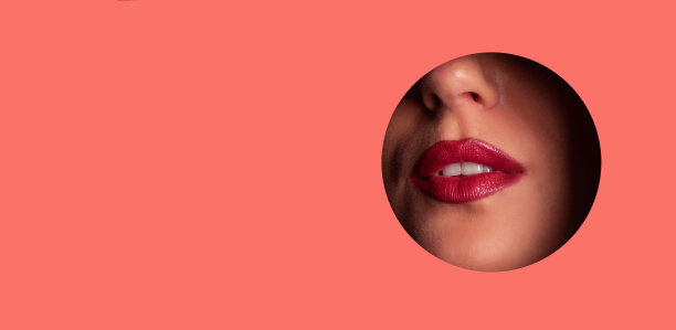 美容院广告横幅，有文案空间。明亮的嘴唇与闪光透过小孔在活珊瑚纸背景。化妆师，美的概念。化妆品销售。图片下载