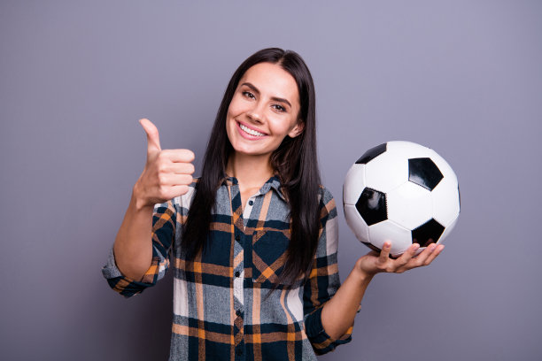 近距离照片她她惊人的美丽女士持有手手臂拇指兴起空气足球足球建议买家购买新模型穿休闲牛仔裤牛仔网纹格子衬衫孤立的灰色背景图片下载