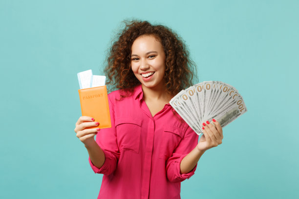滑稽的非洲女孩拿着护照登机牌的车票，扇子里的钱都在美元钞票上，现金孤立在蓝色的绿松石背景上。人真诚情感生活理念。模拟拷贝空间。图片下载