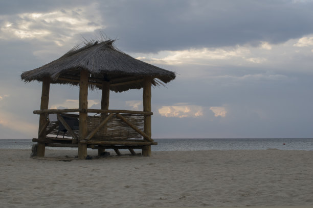 救生员塔在沙滩上——背景是在海里游泳和躺在沙滩上。——图片图片下载