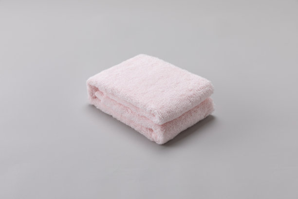灰色背景上折叠的粉红色单毛巾图片下载