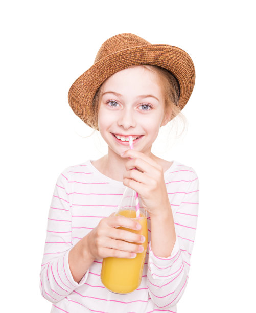 快乐的小女孩戴着一顶帽子喝着一瓶果汁图片下载