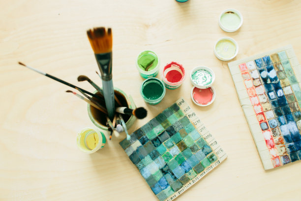 木桌上的陶瓷玻璃里装着绘画工具图片下载