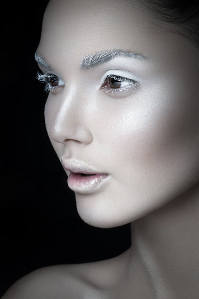 一个年轻女人的特写肖像，与艺术化妆，孤立在一个黑色的背景。创造性的概念。图片下载