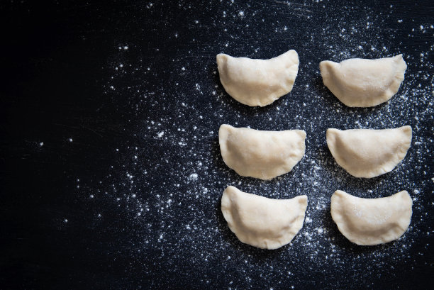 土豆生饺子。准备饺子在黑色的背景图片下载