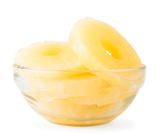 罐装菠萝在一个玻璃盘子近距离在一个白色的背景。图片下载