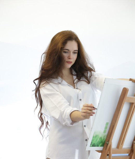 创作过程中，美丽的艺术家女孩在家作画，孤立的背景图片下载