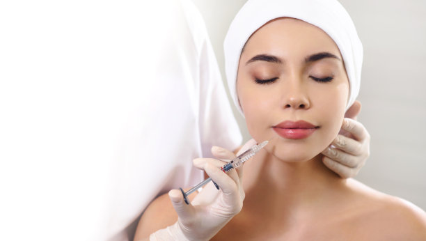 嘴唇注射闭合。注射器与填充脸部轮廓或扩大。快乐的年轻女子正在接受肉毒杆菌注射。医疗美容的概念。白色背景隔离图片下载