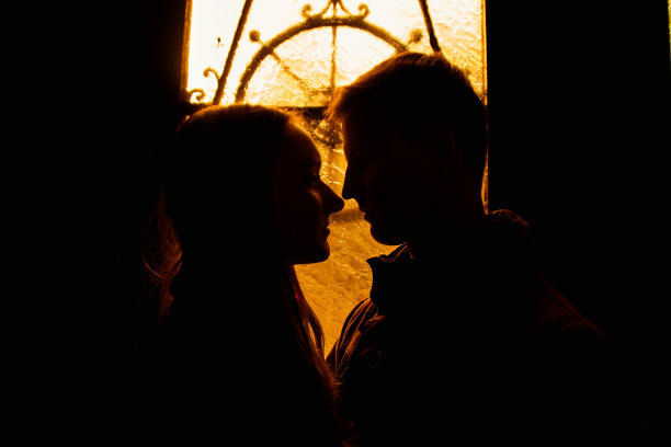 一对恩爱夫妻的剪影。恋人在黑暗中拥抱。一个男人和一个女孩的剪影。情侣近距离拍照。戏剧性的肖像照片。图片下载