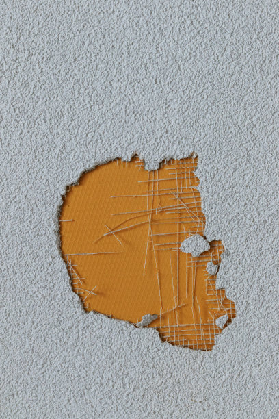 灰泥墙上被黄色表面覆盖的洞图片下载