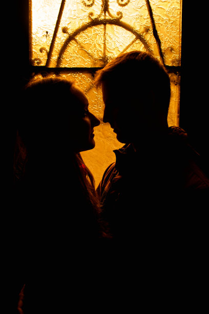 一对恩爱夫妻的剪影。恋人在黑暗中拥抱。一个男人和一个女孩的剪影。情侣近距离拍照。戏剧性的肖像照片。图片下载