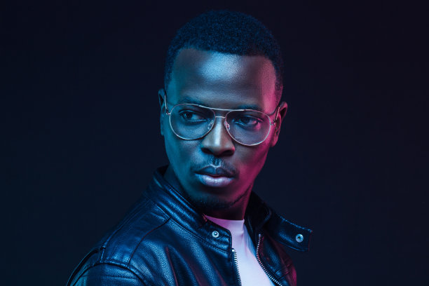 一个非洲人，戴着透明眼镜，穿着黑色皮夹克往一边看图片下载