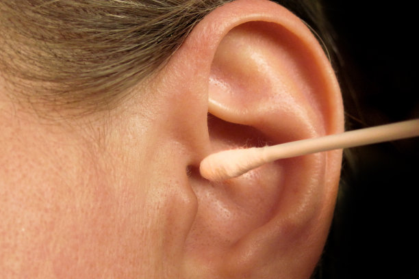 用棉签或棉棒清洁耳朵的中年妇女。家庭卫生保健常规程序的特写图片下载