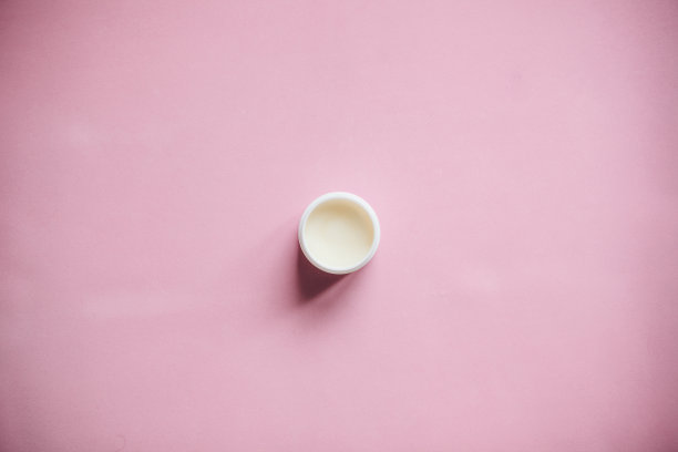 粉色背景上的润肤霜。图片下载