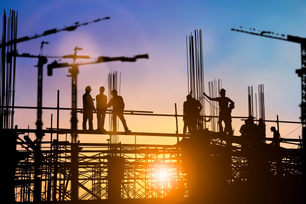 工程师和施工队在现场工作的剪影在模糊的背景与灯光博览会的工业背景。从多个参考图像一起创建图片下载